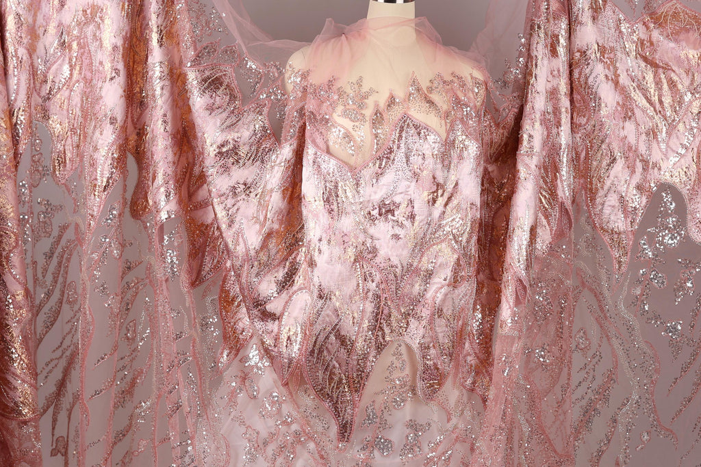 a pink and gold sequined dress with a sheer, flowing skirt.