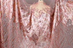 a pink and gold sequined dress with a sheer, flowing skirt.
