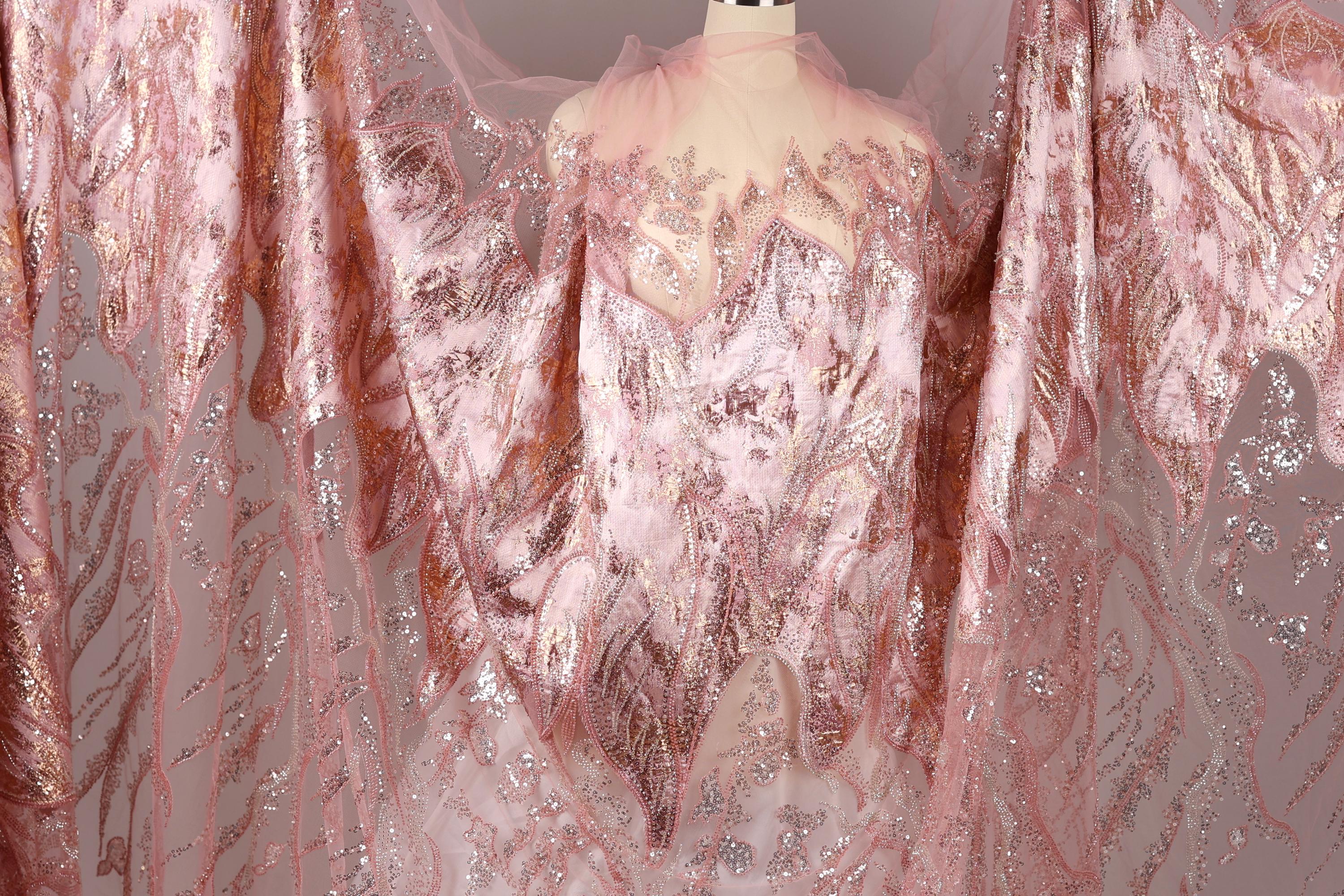 a pink and gold sequined dress with a sheer, flowing skirt.