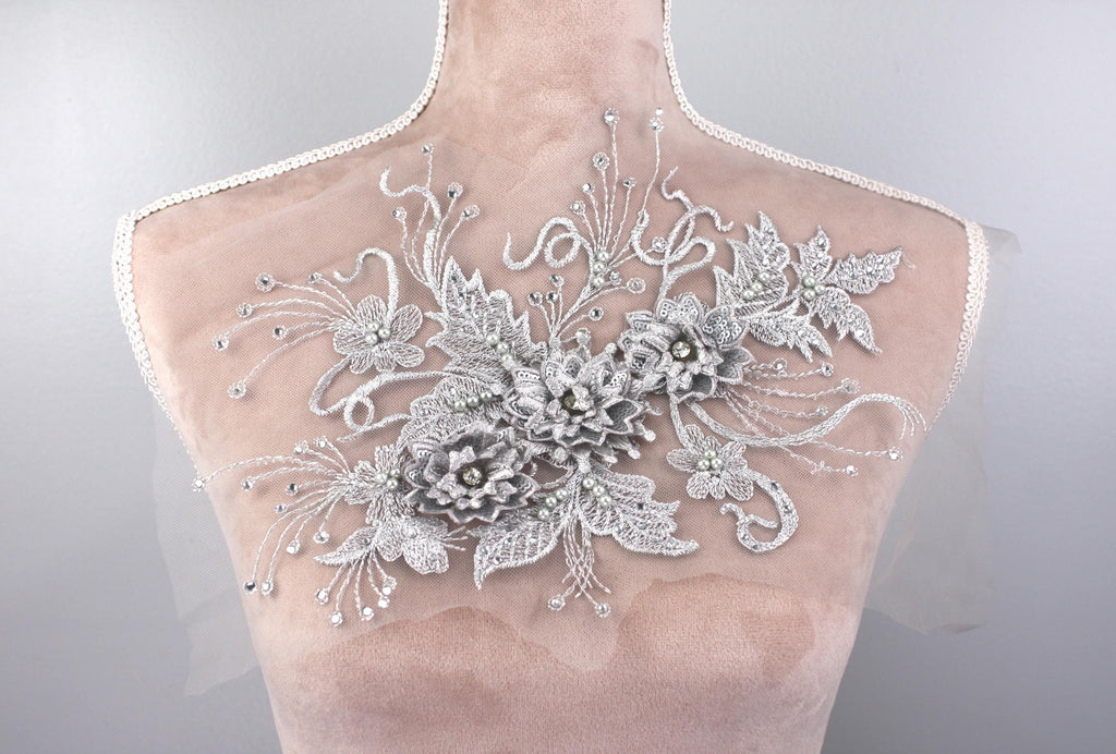 A mannequin torso with a decorative floral embroidery on the back.