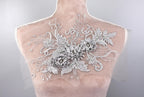 A mannequin torso with a decorative floral embroidery on the back.