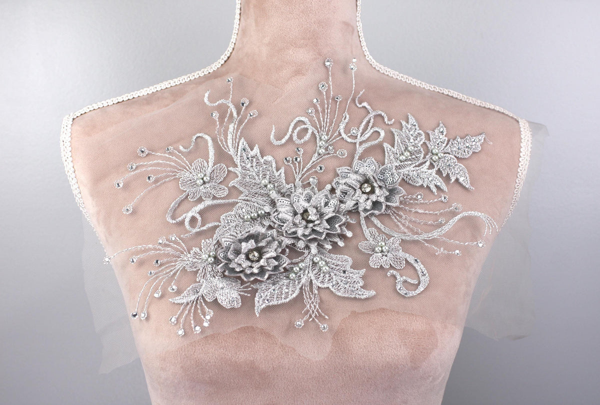 A mannequin torso with a decorative floral embroidery on the back.