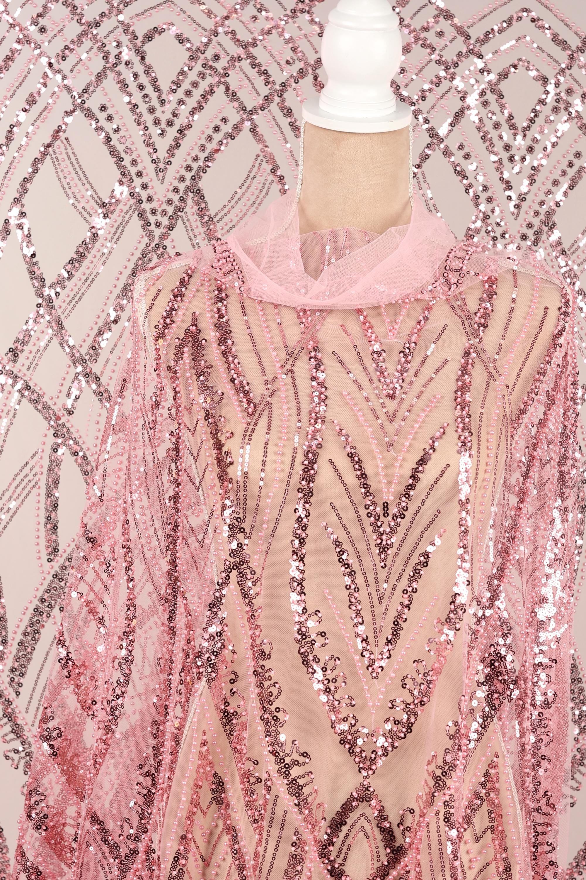 a mannequin wearing a pink sequin dress with a sheer overlay.