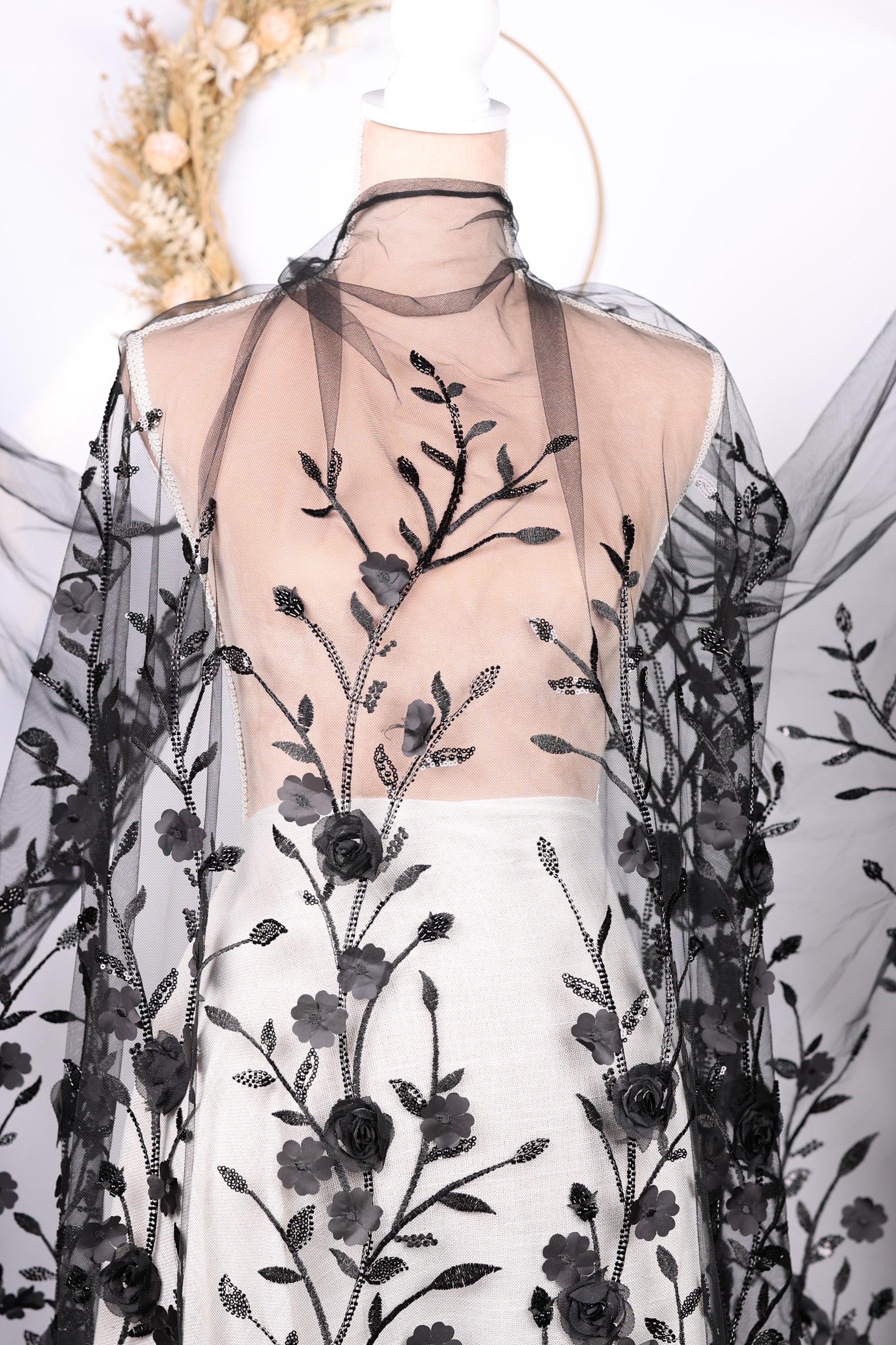 a dress with a black floral pattern on the bodice and sheer fabric with black floral designs.