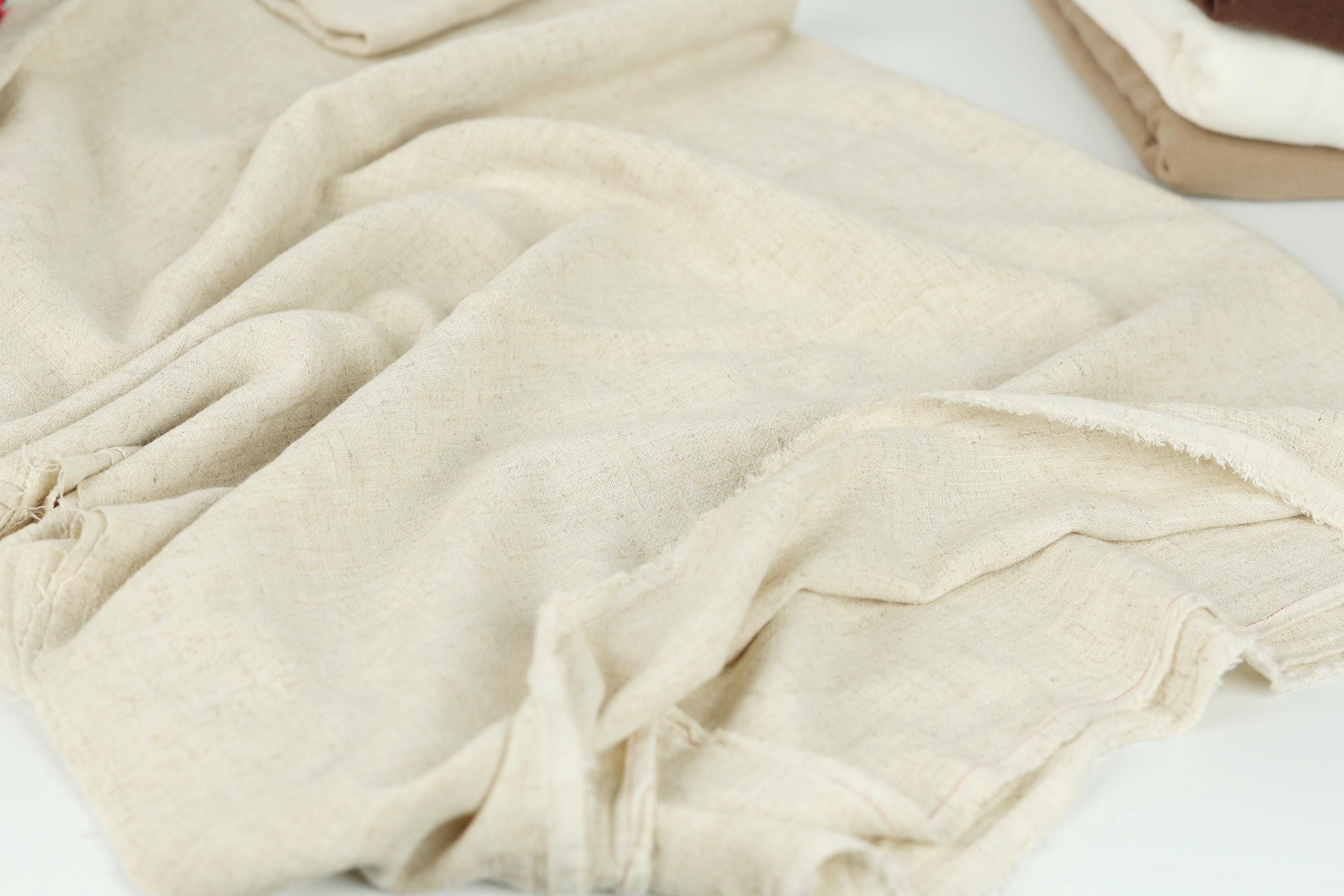 A close-up view of a crumpled, light-colored fabric, possibly a piece of clothing or a textile.
