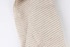 A close-up view of a fabric with horizontal black stripes on a beige background.