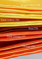 a close-up of various fabric swatches in different colors, including bright yellow, dark yellow, rust, dark orange, and orange.