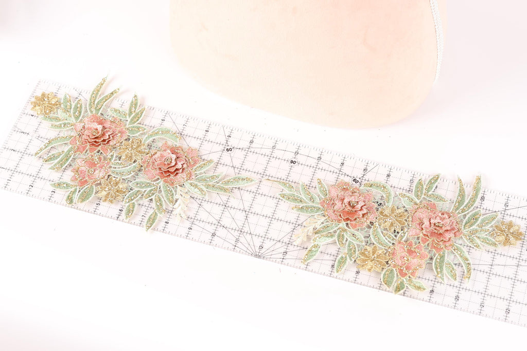 a floral pattern with pink and green flowers on a ruler, suggesting a craft or sewing project.
