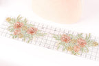 a floral pattern with pink and green flowers on a ruler, suggesting a craft or sewing project.
